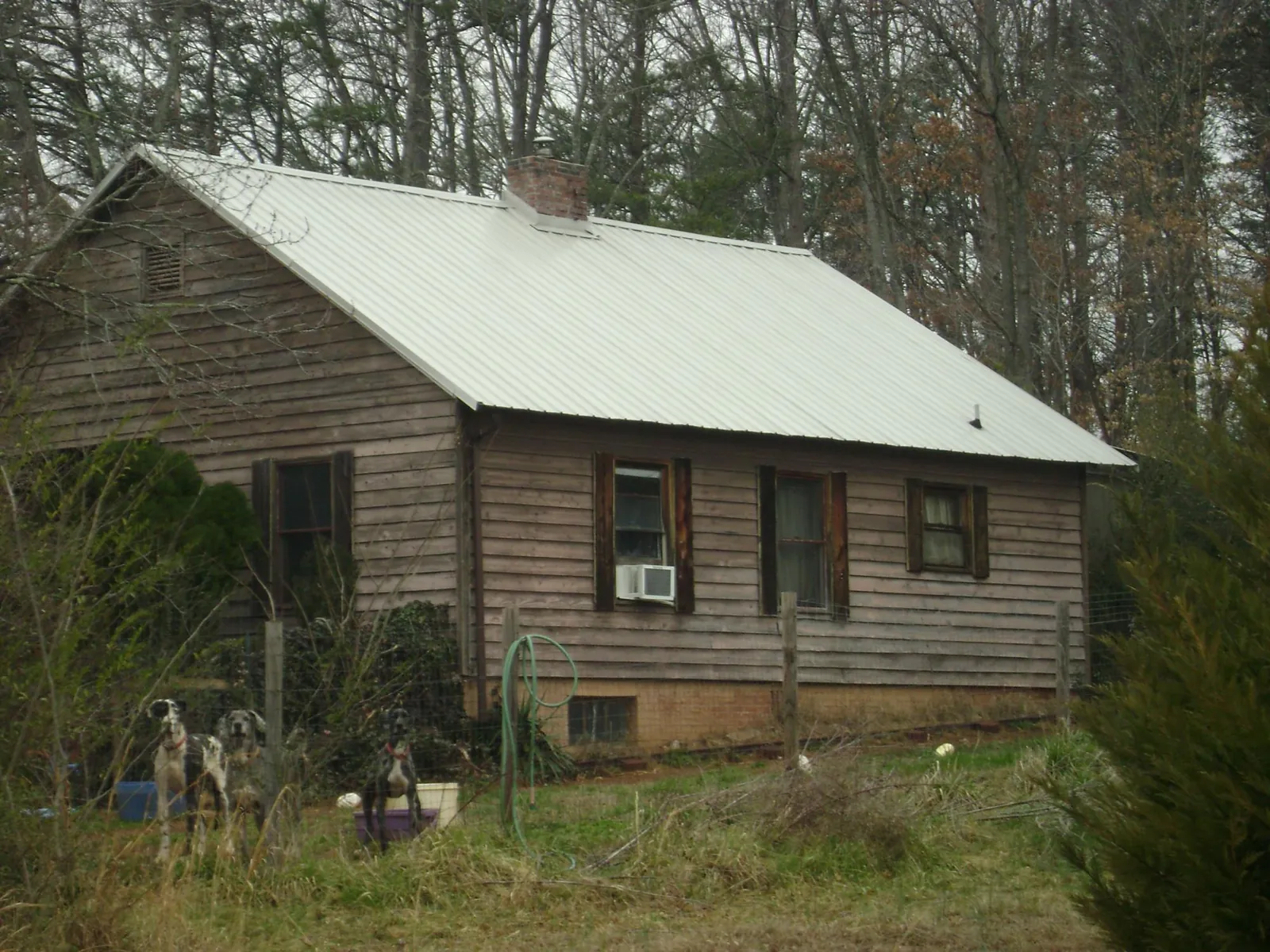 White metal roof on an old wood sided farmhouse, from a Metal Roof Installation job in Georgetown